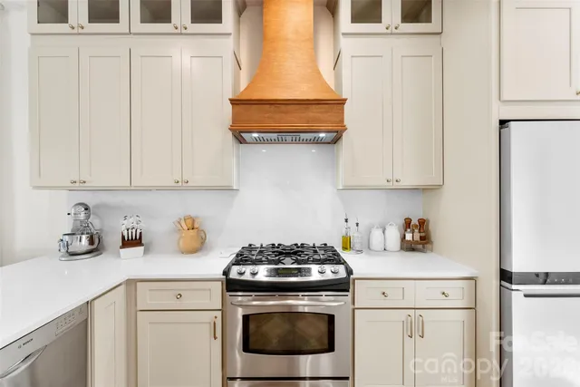 a kitchen with stainless steel appliances granite countertop white cabinets and a stove