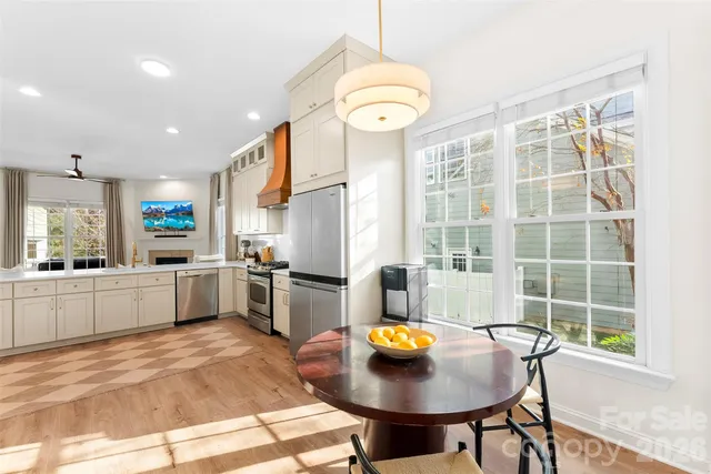 a kitchen with a sink a kitchen island a stove and a refrigerator with wooden floor