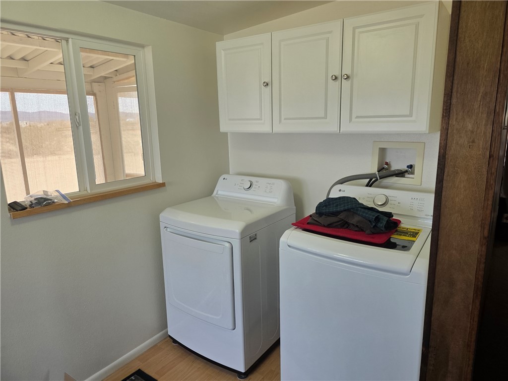 3325 Bacobi Road Golden Valley, AZ 86413 - Photo 31 of 44 Washroom featuring washer and clothes dryer, cabinet space, and light wood-style flooring
