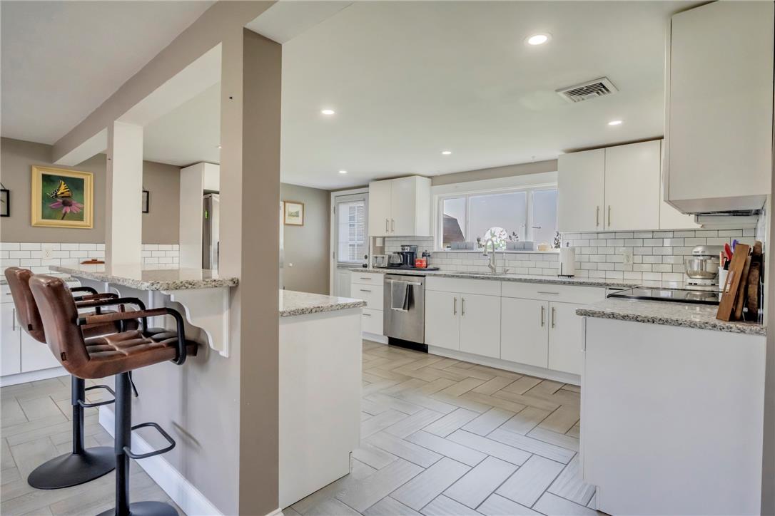 439 Cherry Hill Road Nazareth, PA 18064 - Photo 6 of 31 A well-lit kitchen with sleek white cabinetry and elegant granite countertops.