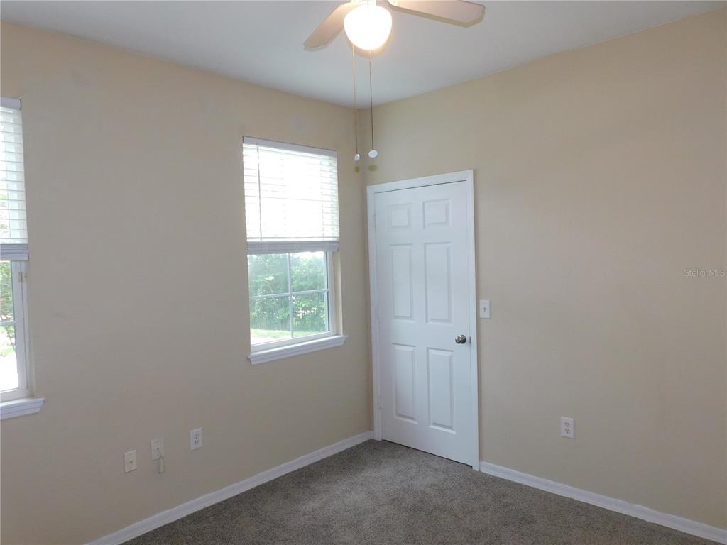 3480 Soho Street, Unit 101 Orlando, FL 32835 - Photo 18 of 29 an empty room with a window and a chandelier fan