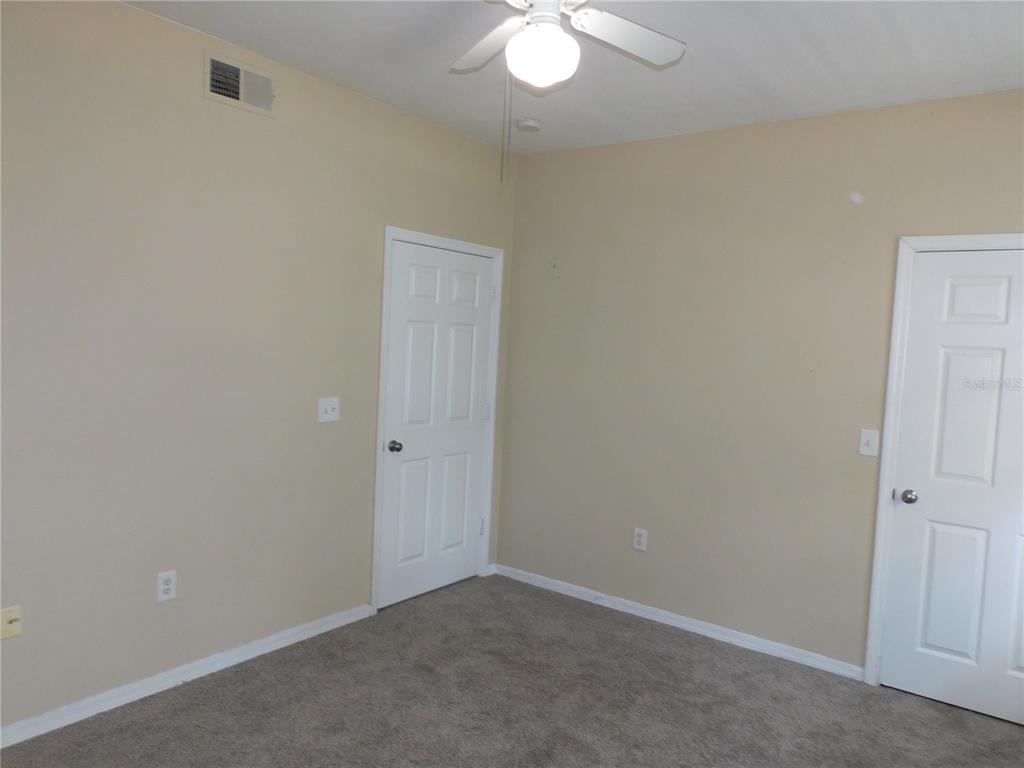3480 Soho Street, Unit 101 Orlando, FL 32835 - Photo 23 of 29 an empty room with a chandelier fan