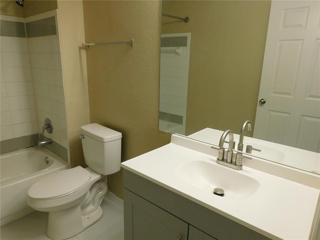 3480 Soho Street, Unit 101 Orlando, FL 32835 - Photo 25 of 29 a bathroom with a sink a toilet and shower