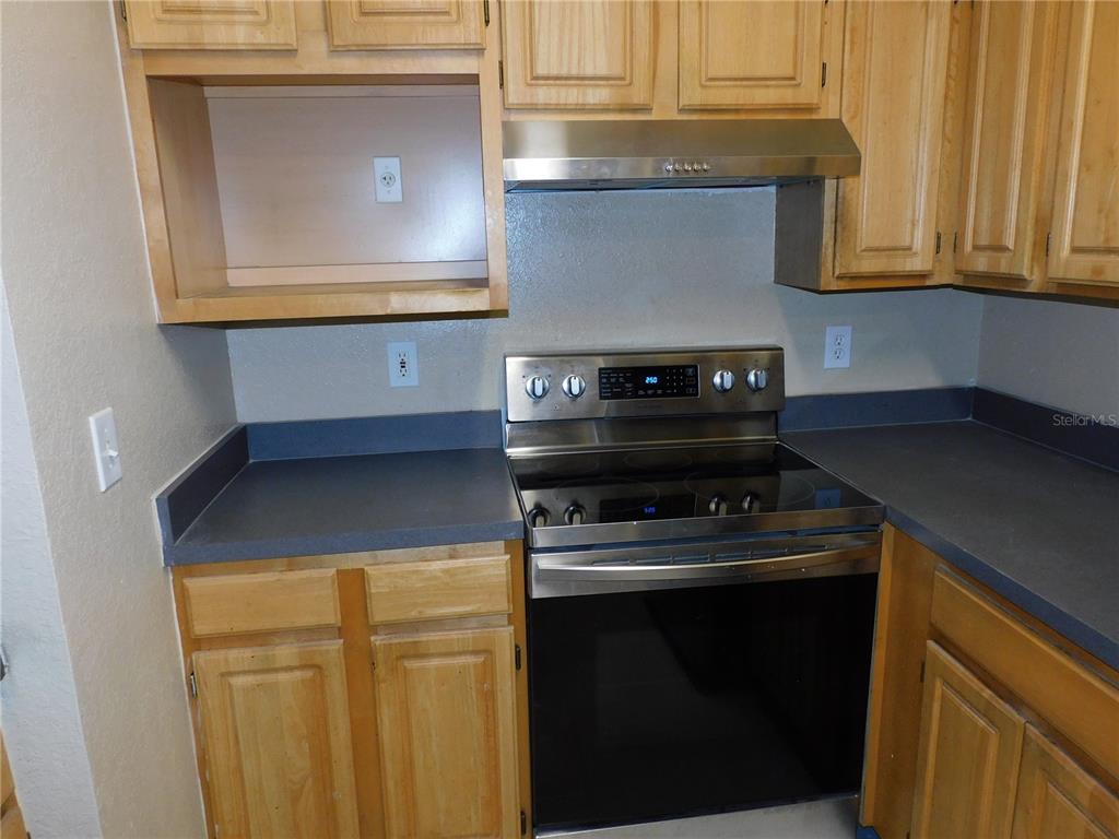 3480 Soho Street, Unit 101 Orlando, FL 32835 - Photo 7 of 29 a kitchen with granite countertop white cabinets and black appliances