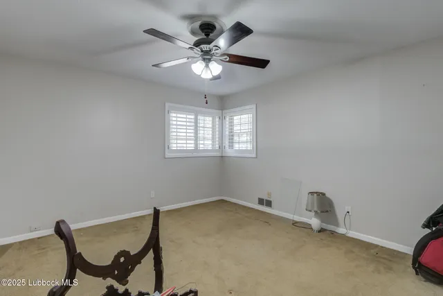 a spacious bedroom with a bed and a ceiling fan