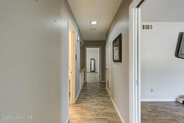 a view of empty room with wooden floor and windows