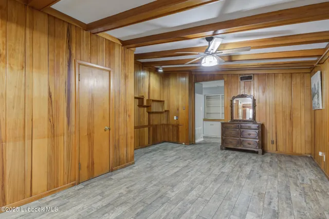 a view of empty room with wooden floor and floor to ceiling window