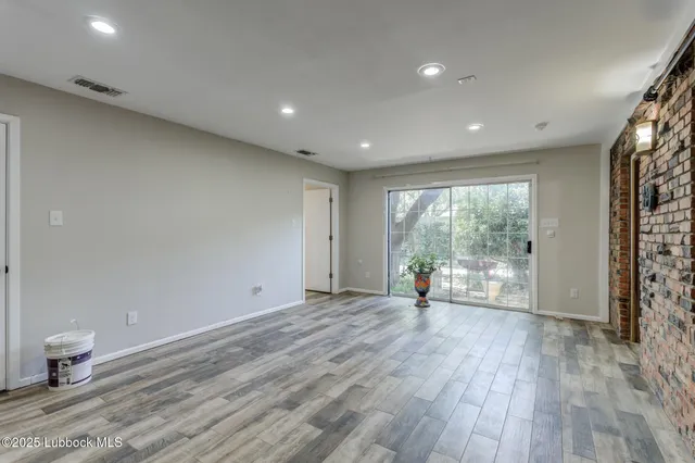 a backyard of a house with large trees and brick wall
