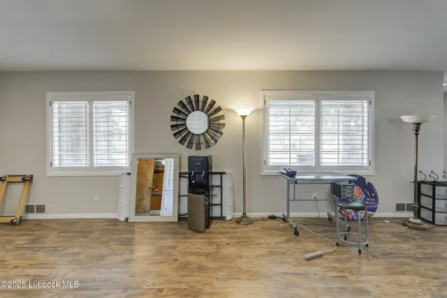 a view of a room with windows and chandelier fan