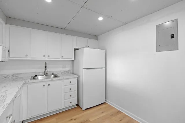 a kitchen with a sink a refrigerator and cabinets