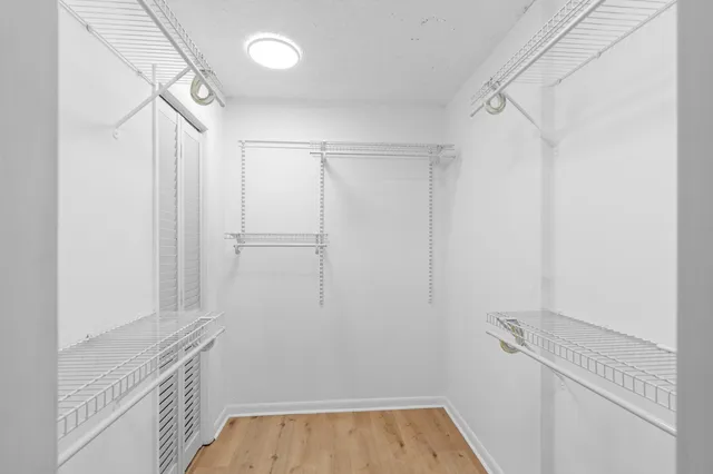 a view of walk in closet with empty racks