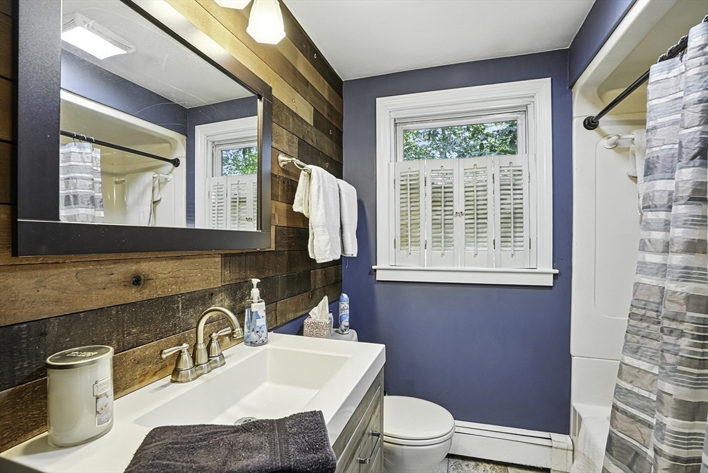 334 Mendon Road Northbridge, MA 01534 - Photo 16 of 31 a bathroom with a granite countertop toilet a sink a mirror and a window