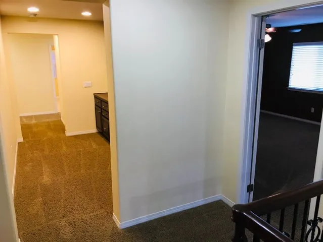 a view of empty room with a fan and a potted plant