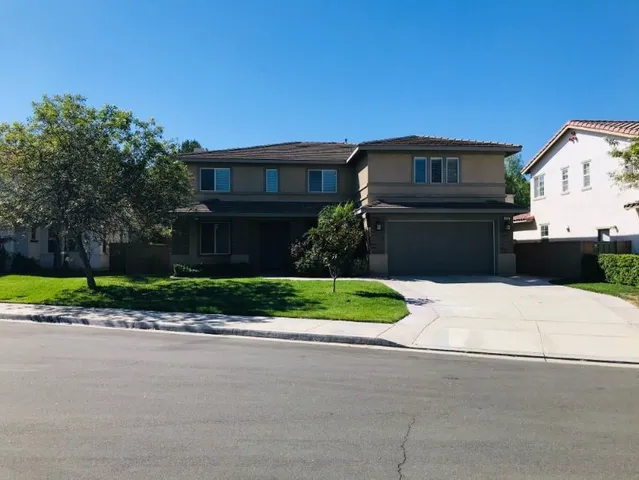 a front view of a house with a garden and plants