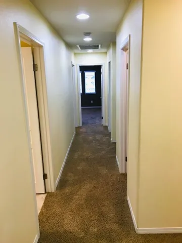 an empty room with closet and a chandelier fan