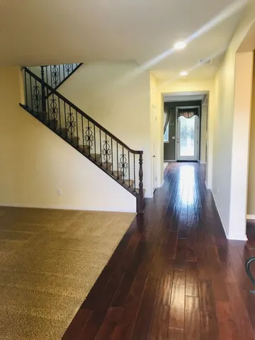 a view of a hallway with wooden floor