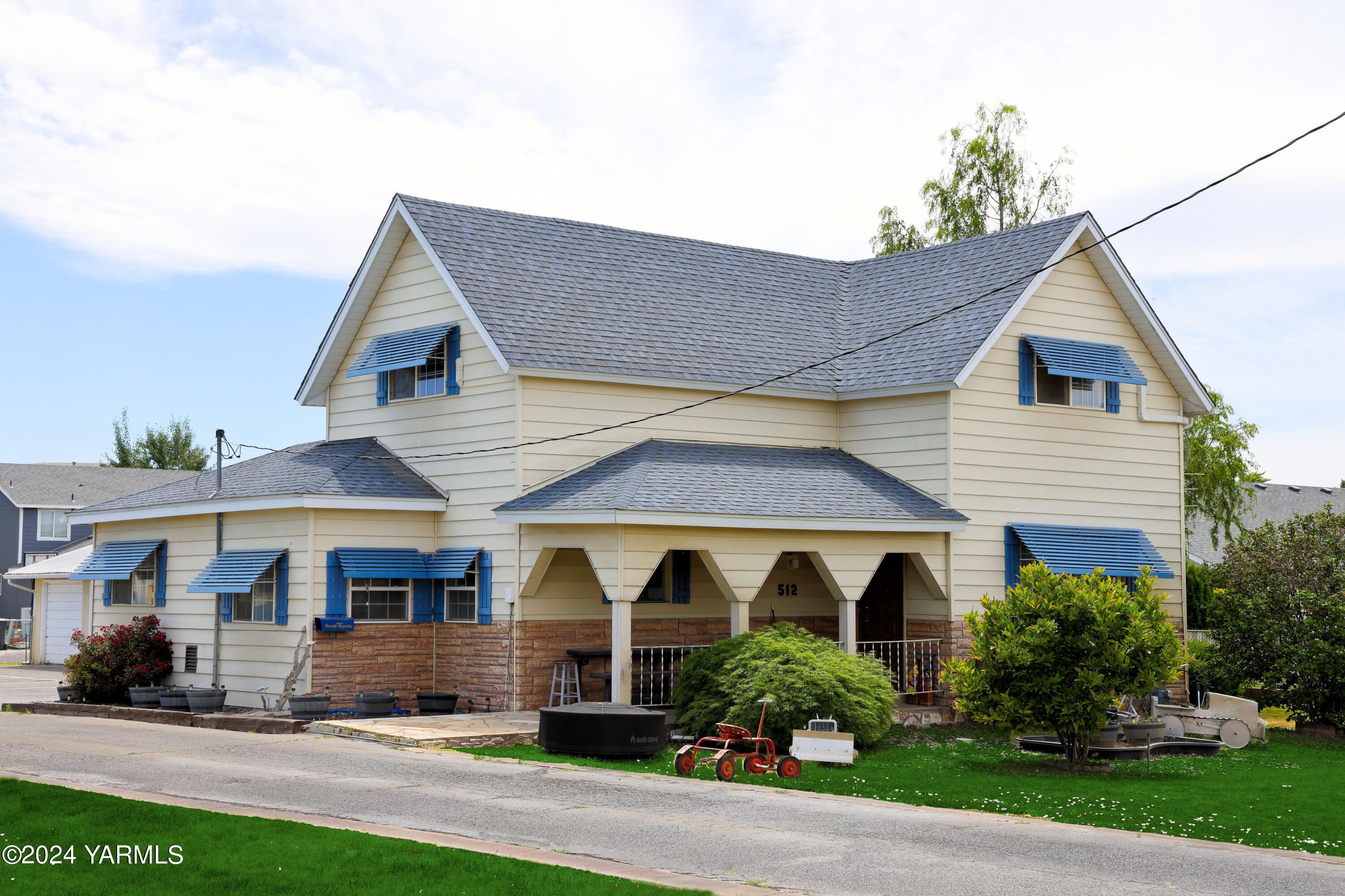 a front view of a house with a yard and plants