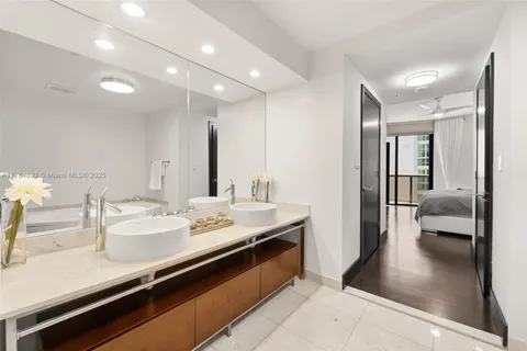 a en suite bathroom with a sink double vanity and a mirror