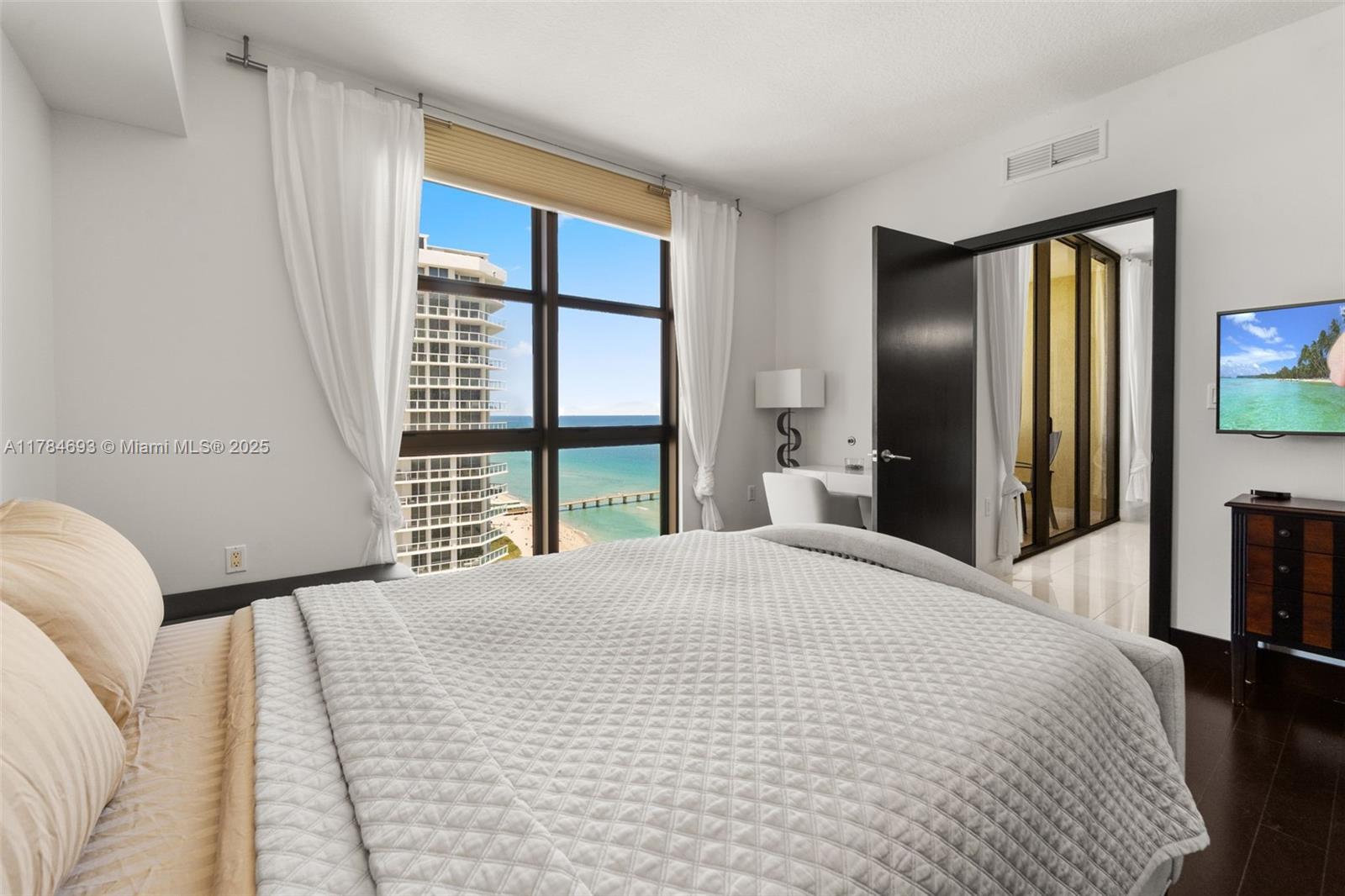 16275 Collins Avenue, Unit 2202 Sunny Isles Beach, FL 33160 - Photo 12 of 23 a bedroom with a bed and a large window