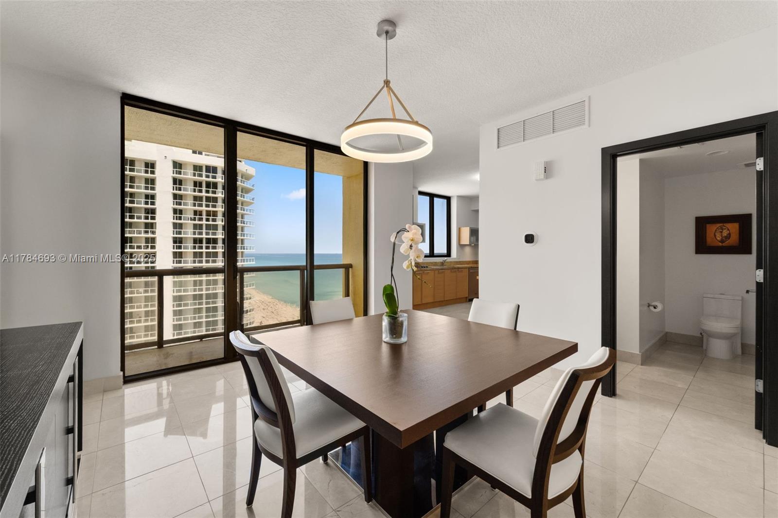 16275 Collins Avenue, Unit 2202 Sunny Isles Beach, FL 33160 - Photo 6 of 23 a view of a dining room with furniture window and wooden floor