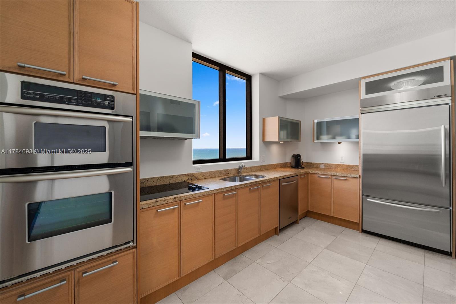 16275 Collins Avenue, Unit 2202 Sunny Isles Beach, FL 33160 - Photo 7 of 23 a kitchen with stainless steel appliances granite countertop a stove microwave and a refrigerator