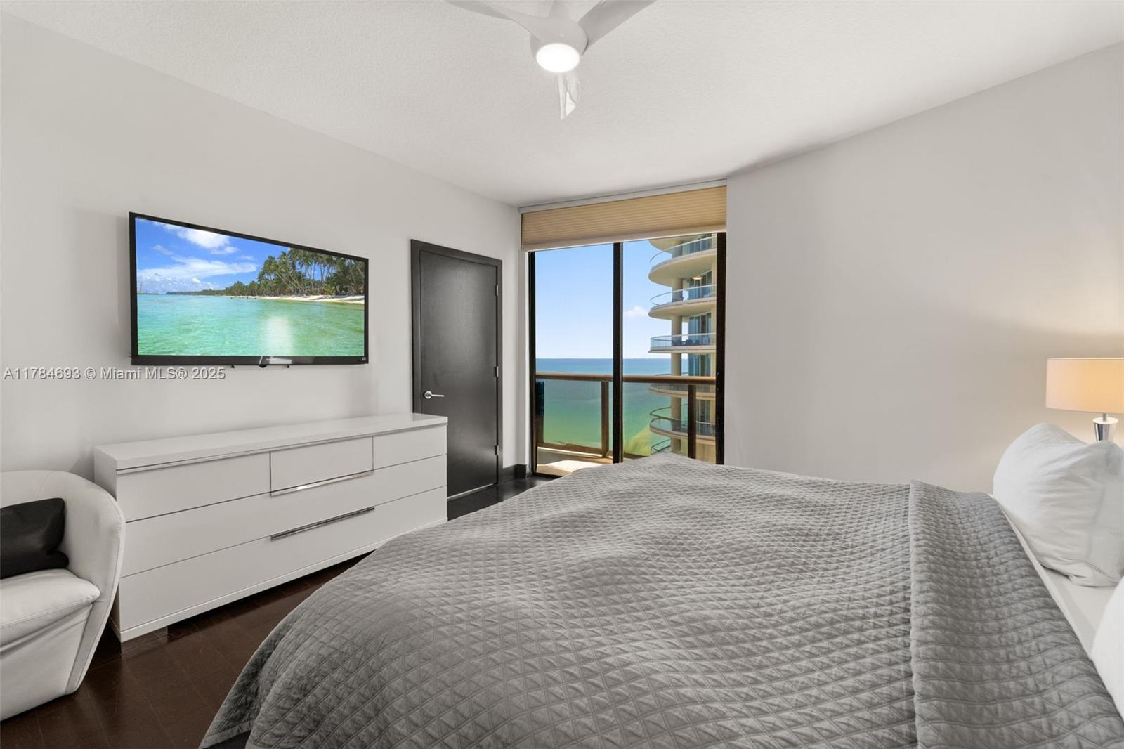 16275 Collins Avenue, Unit 2202 Sunny Isles Beach, FL 33160 - Photo 8 of 23 a bedroom with a bed and a flat screen tv