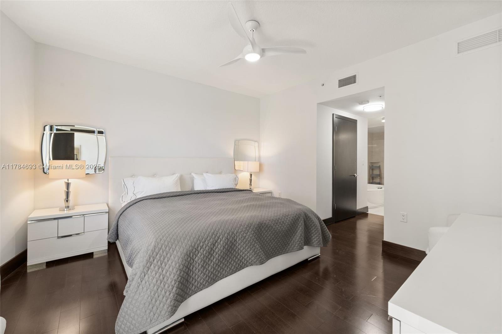 16275 Collins Avenue, Unit 2202 Sunny Isles Beach, FL 33160 - Photo 9 of 23 a bedroom with a bed and a night stand