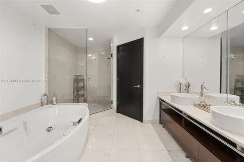 a spacious bathroom with a tub sink and mirror
