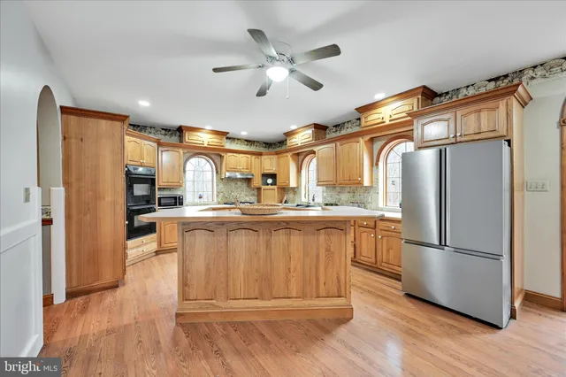 a kitchen with stainless steel appliances granite countertop a refrigerator and a stove top oven