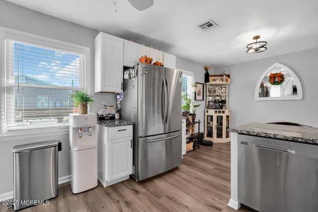 a kitchen with granite countertop a refrigerator and a stove top oven