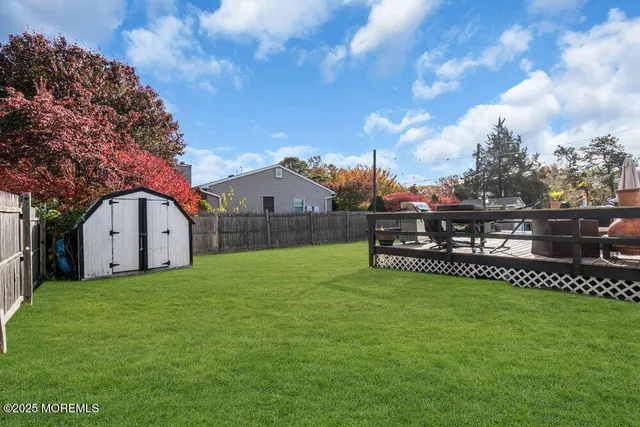 a view of a house with a yard and a large tree