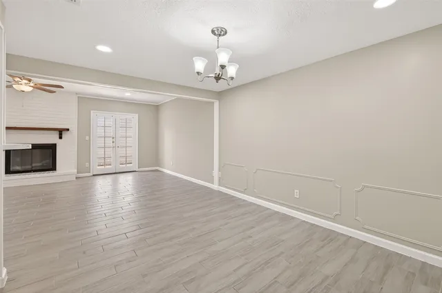 a view of a livingroom with a fireplace wooden floor and windows
