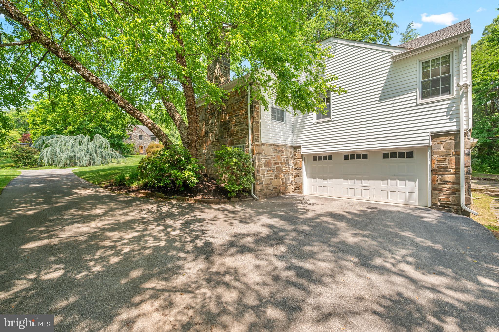 653 Broad Acres Road Penn Valley, PA 19072 - Photo 8 of 35 a view of a house with a yard and garage
