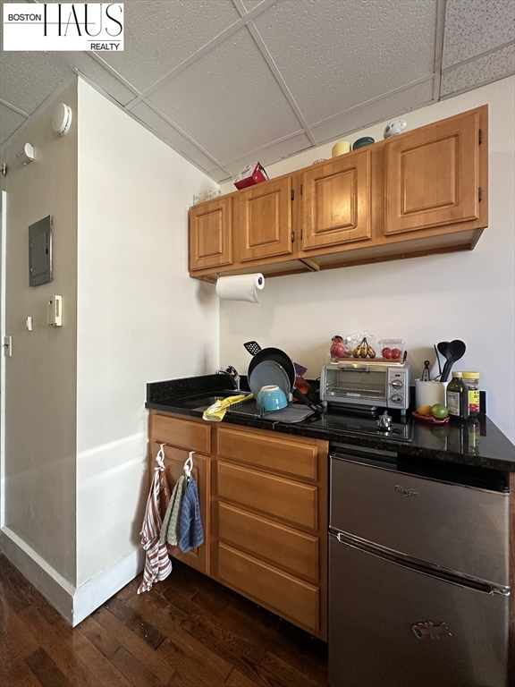 505 Beacon Street, Unit 12 Boston, MA 02215 - Photo 5 of 5 a kitchen with stainless steel appliances granite countertop a sink dishwasher stove and cabinets with wooden floor