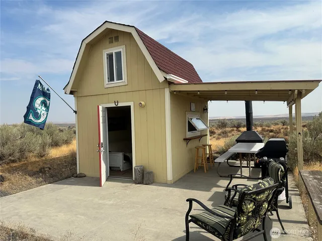 a view of roof deck with table and chairs and potted plants