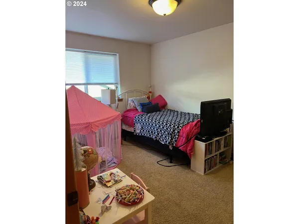 a bedroom with a bed and a wall painting