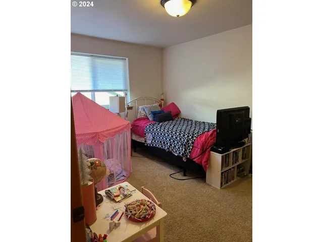 a bedroom with a bed and a wall painting