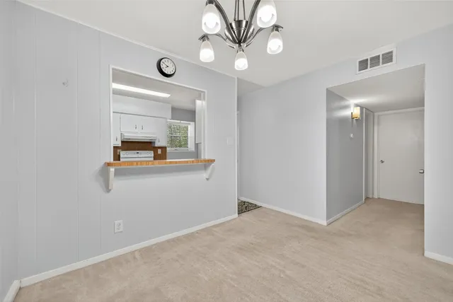 a view of a hallway to room with wooden floor