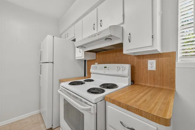 a kitchen with white cabinets and white appliances