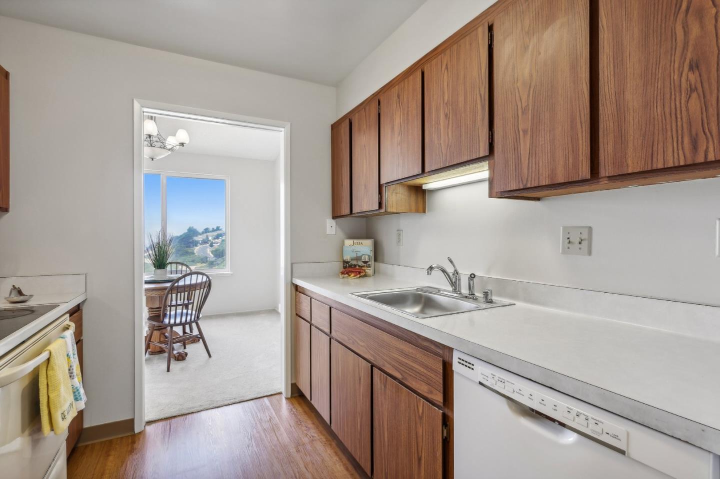 5003 Palmetto Avenue, Unit 89 Pacifica, CA 94044 - Photo 17 of 46 a kitchen with a sink a stove cabinets and wooden floor