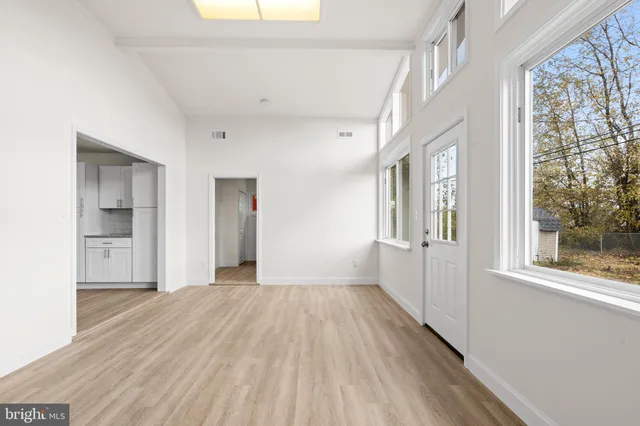 a view of a big room with wooden floor and windows