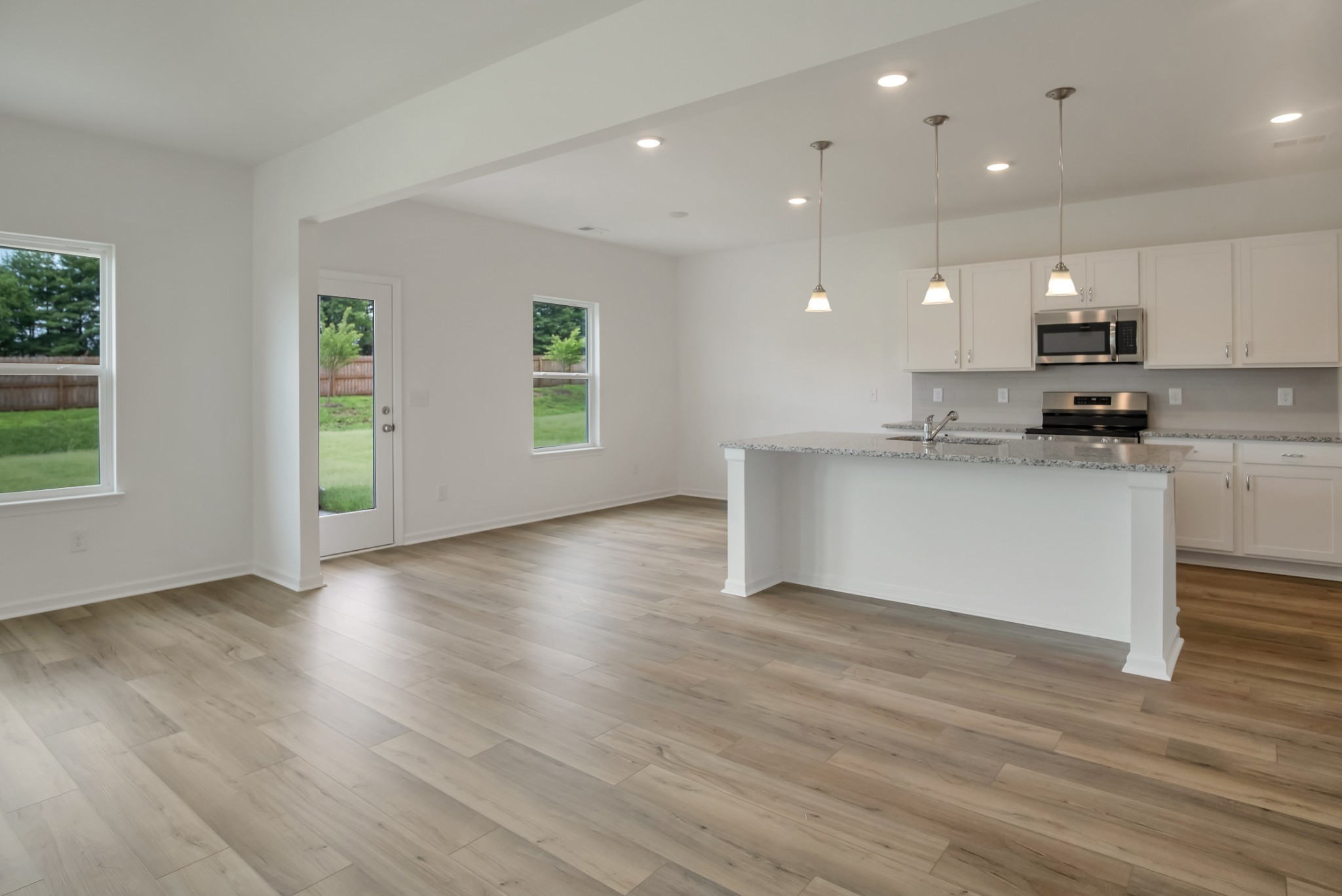 769 Chiswick Court Lebanon, TN 37087 - Photo 14 of 44 an open kitchen with kitchen island a sink wooden floor and a stove top oven
