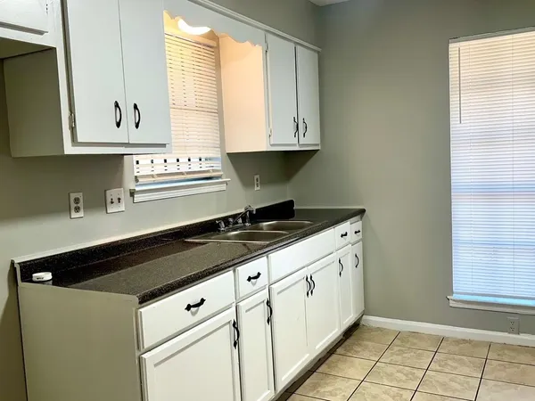 a kitchen with granite countertop white cabinets and white appliances