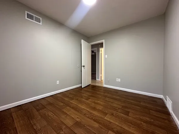 a view of an empty room with wooden floor