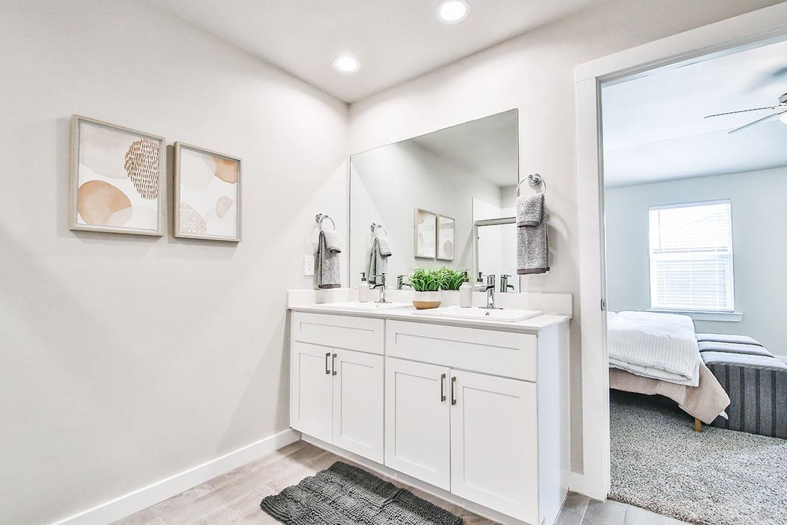 7735 92nd Street Lubbock, TX 79424 - Photo 11 of 12 a spacious bathroom with a double vanity sink and a mirror