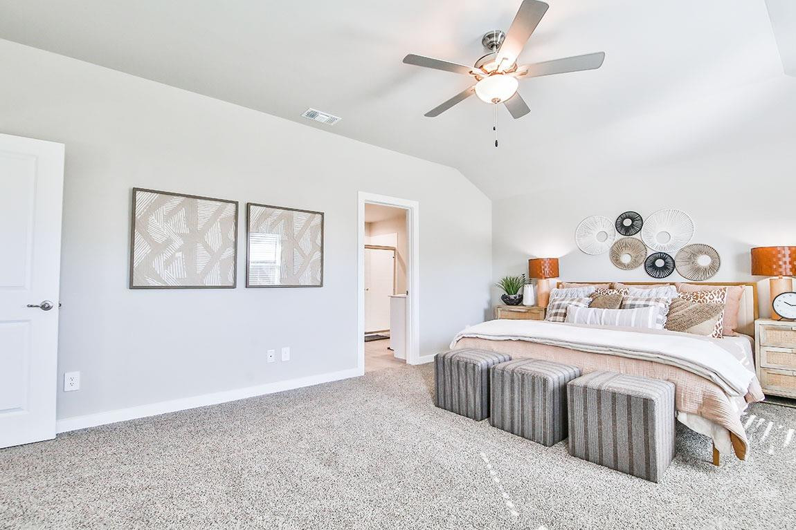 7735 92nd Street Lubbock, TX 79424 - Photo 5 of 12 a bedroom with a large bed and a chandelier
