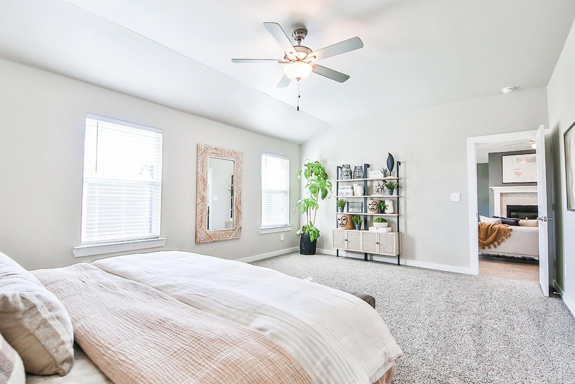 7735 92nd Street Lubbock, TX 79424 - Photo 9 of 12 a spacious bedroom with a large bed and ceiling fan