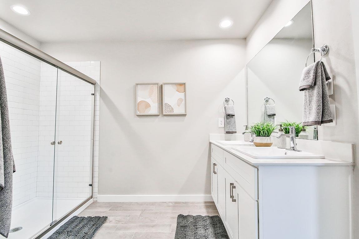7735 92nd Street Lubbock, TX 79424 - Photo 10 of 12 a bathroom with a double vanity sink and a mirror