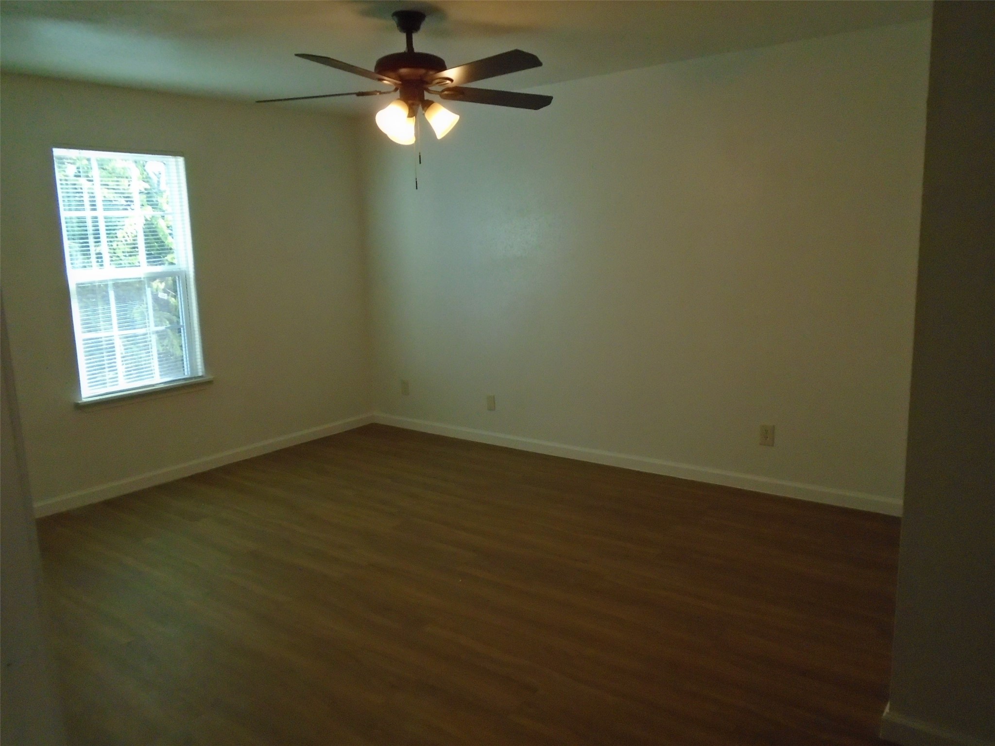 9898 Club Creek Drive, Unit 1817 Houston, TX 77036 - Photo 4 of 8 an empty room with a window and a fan