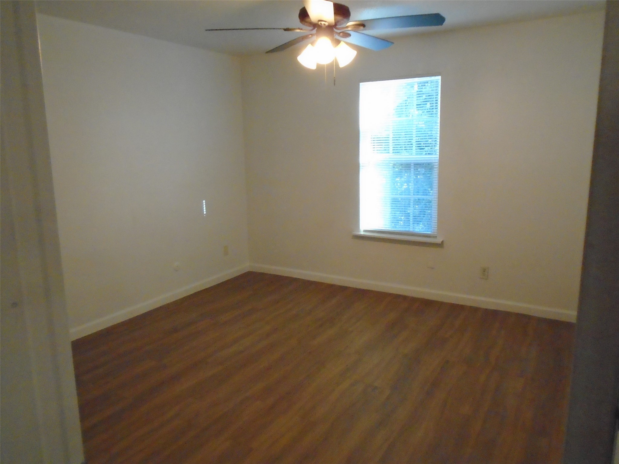 9898 Club Creek Drive, Unit 1817 Houston, TX 77036 - Photo 6 of 8 wooden floor in an empty room with a window